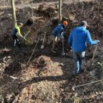 Drei Männer stehen am Pyhra Trail und sind mit Wiederherstellungsarbeiten beschäftigt. Sie arbeiten mit Schaufeln und Trailbautools.